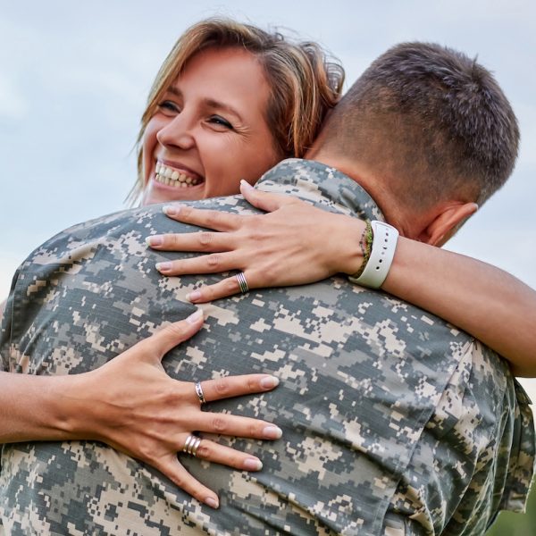 Happy woman hugging his husband came back from army.